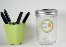 Load image into Gallery viewer, Date open label on a clear empty jar. Green outline with a cute orange figure.
