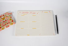 Load image into Gallery viewer, Weekly to-do list pad with a pen and floral notebook on a white background
